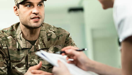 Woman helping a veteran fill out paperwork.